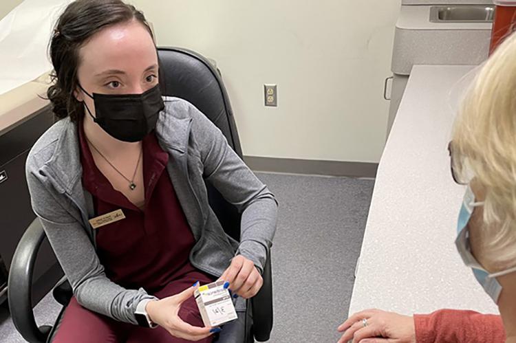 UMKC 药学院 student Amelia Godfrey talks with a patient at Hannibal Free Clinic.