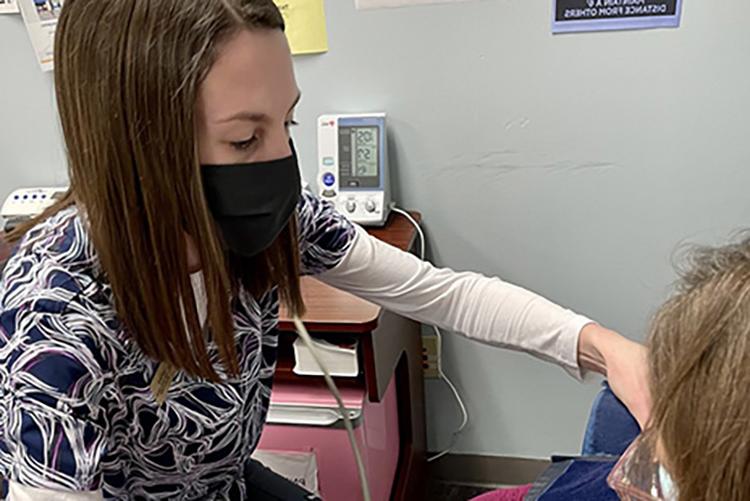 UMKC 药学院 student 劳伦·达蒙 takes a patient's blood pressure at Hannibal Free Clinic.